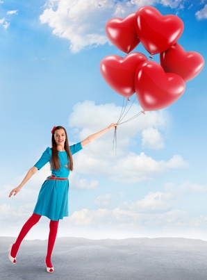 Woman holding a group of heart shaped balloons